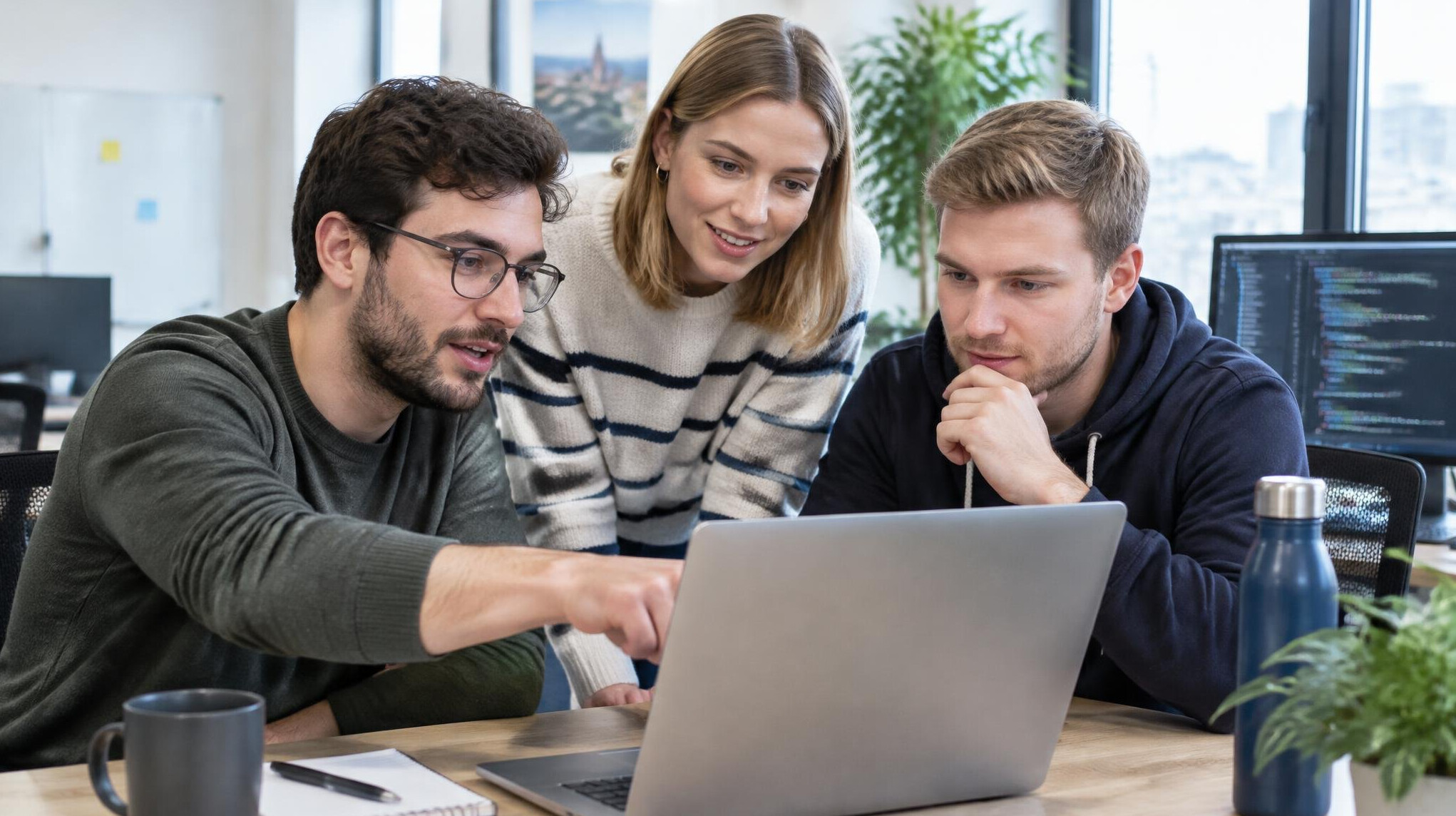 Small team of developers collaborating around a laptop
